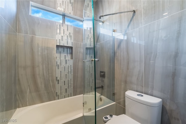 bathroom with toilet and tiled shower / bath