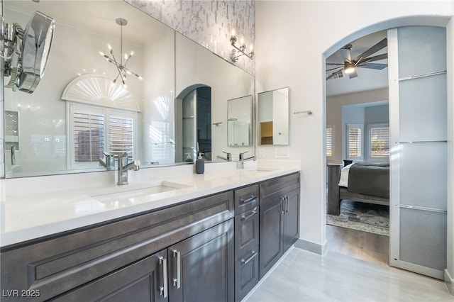 bathroom featuring ceiling fan with notable chandelier, plenty of natural light, and vanity