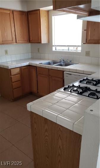 kitchen featuring sink, tile countertops, and light tile patterned flooring