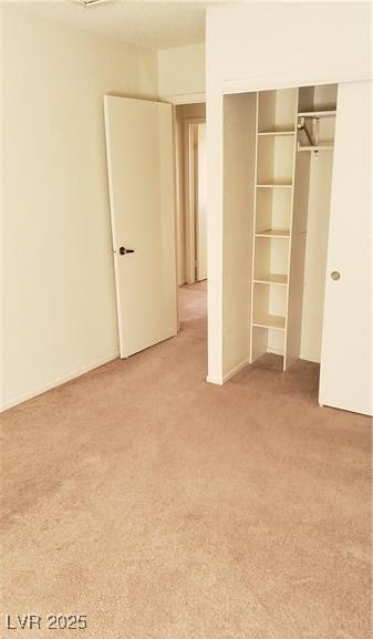 unfurnished bedroom featuring carpet flooring and a closet