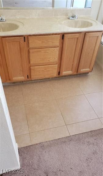 bathroom with toilet, vanity, and tile patterned floors