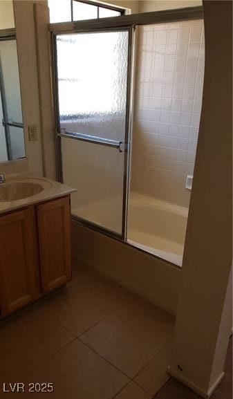 bathroom featuring tile patterned flooring, vanity, and combined bath / shower with glass door