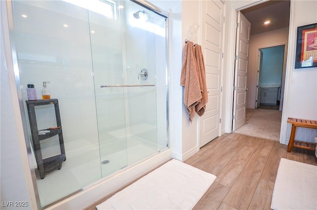 bathroom featuring hardwood / wood-style flooring and a shower with door