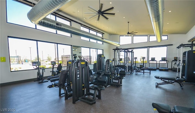 workout area featuring ceiling fan and a towering ceiling