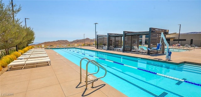 view of pool featuring a mountain view and a patio