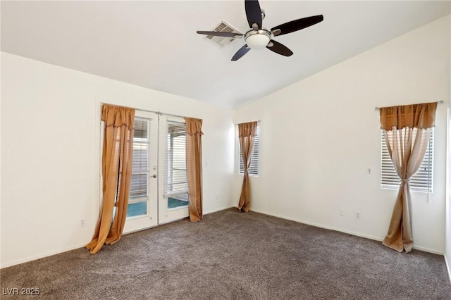 empty room with dark colored carpet, ceiling fan, vaulted ceiling, and french doors