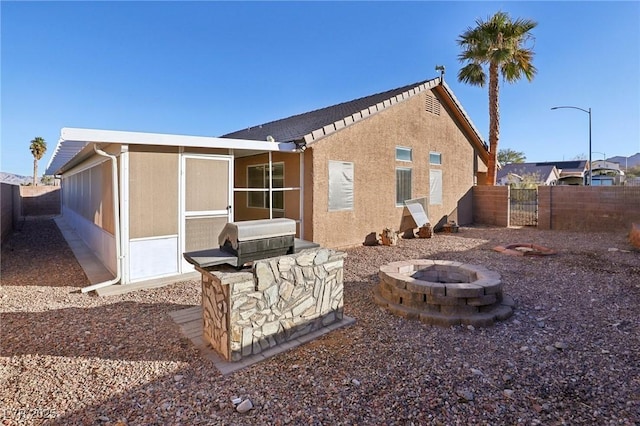 rear view of house featuring an outdoor fire pit