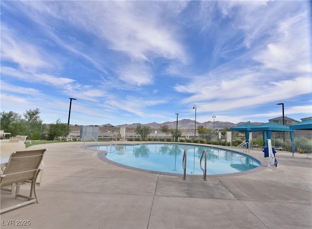 view of swimming pool with a mountain view and a patio area