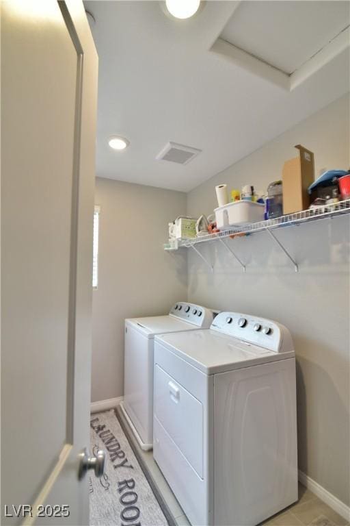 washroom featuring washing machine and dryer and light tile patterned floors