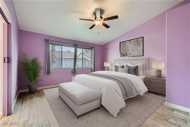 bedroom featuring light wood-type flooring, vaulted ceiling, and ceiling fan