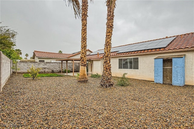 rear view of property with solar panels