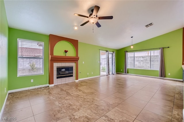 unfurnished living room featuring a tile fireplace, light tile patterned floors, vaulted ceiling, and ceiling fan