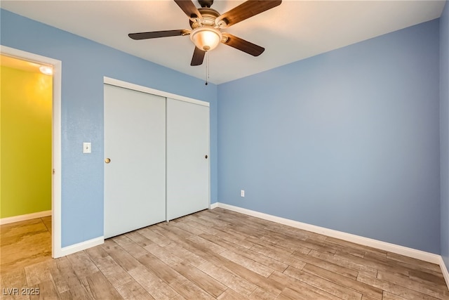 unfurnished bedroom with ceiling fan, a closet, and light hardwood / wood-style floors