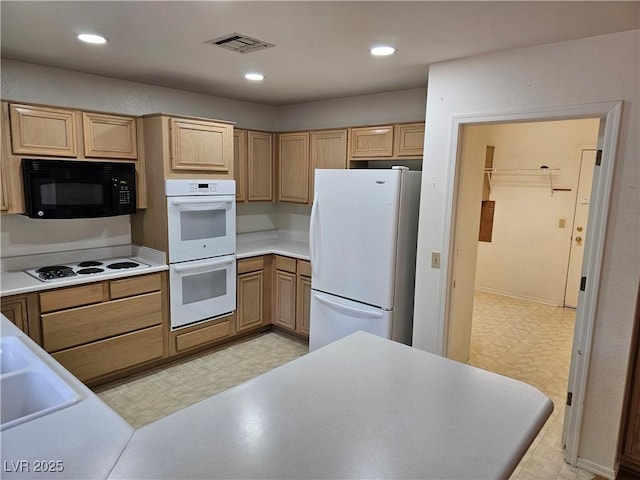 kitchen with light brown cabinets, white appliances, and sink