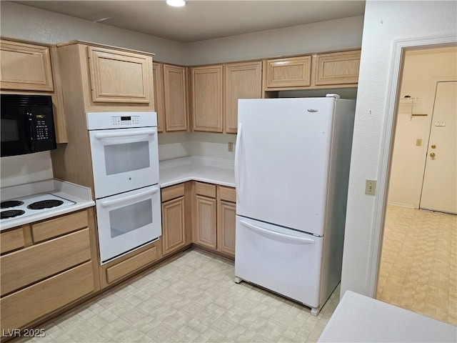 kitchen featuring light brown cabinets and white appliances