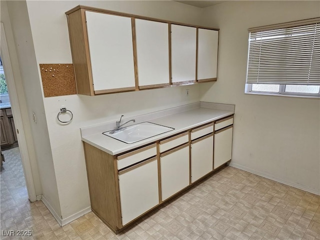 kitchen featuring white cabinetry and sink