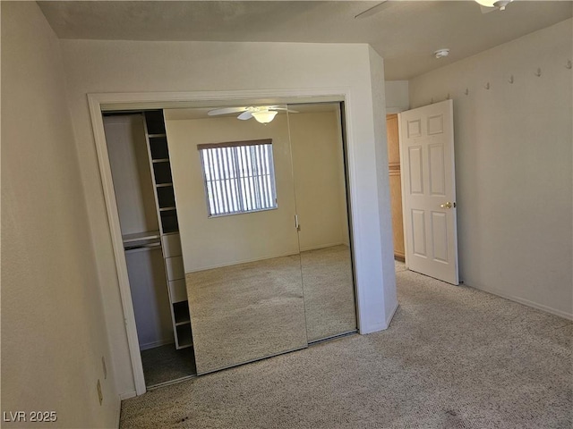 unfurnished bedroom featuring ceiling fan, light carpet, and a closet