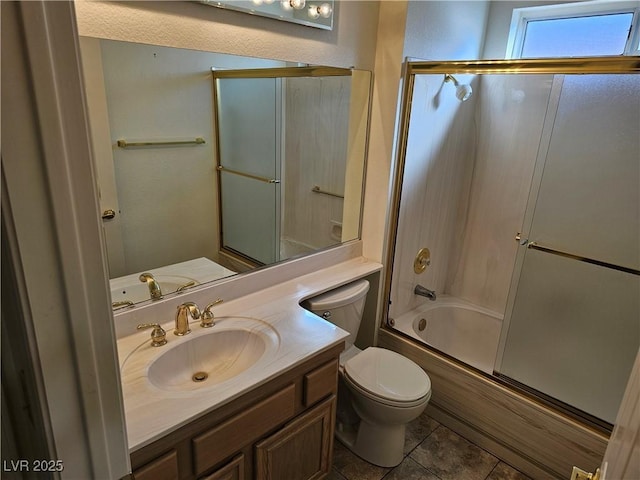 full bathroom featuring tile patterned flooring, vanity, toilet, and bath / shower combo with glass door