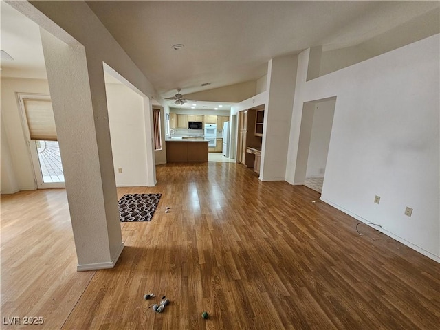 unfurnished living room with ceiling fan, hardwood / wood-style floors, and vaulted ceiling