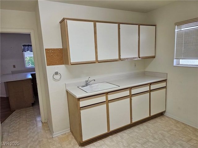 kitchen featuring white cabinetry and sink