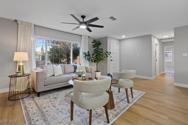 living room with ceiling fan and light hardwood / wood-style flooring