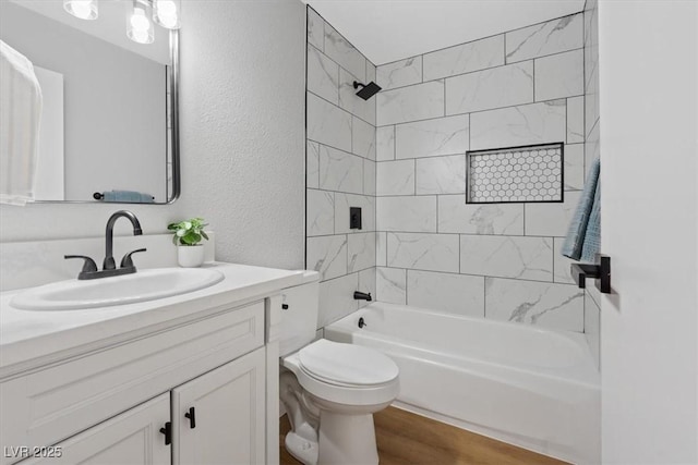 full bathroom with hardwood / wood-style flooring, toilet, vanity, and tiled shower / bath