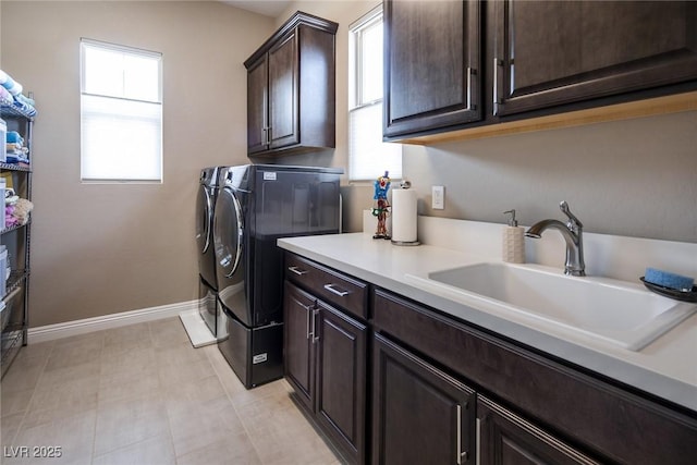 washroom featuring cabinets, sink, a wealth of natural light, and washing machine and clothes dryer