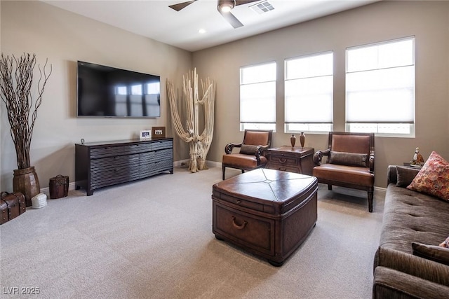 carpeted living room featuring a wealth of natural light and ceiling fan