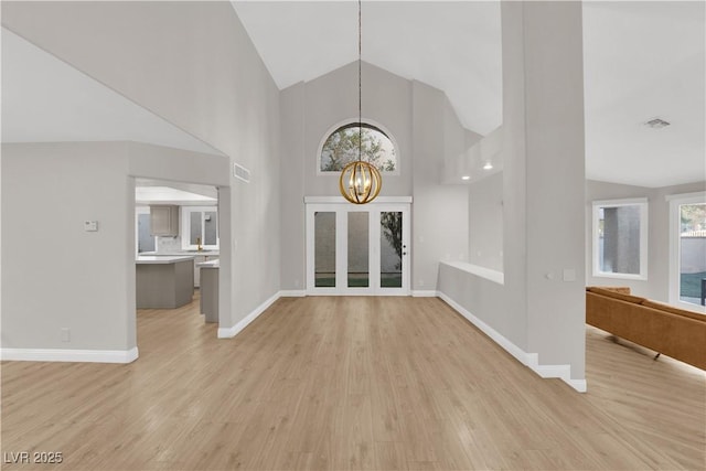 interior space featuring high vaulted ceiling, a chandelier, and light hardwood / wood-style floors