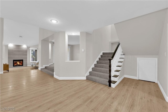 staircase featuring a fireplace and wood-type flooring