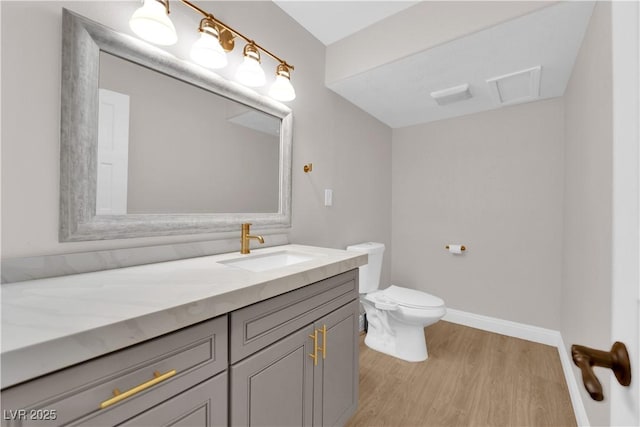 bathroom featuring vanity, hardwood / wood-style flooring, and toilet