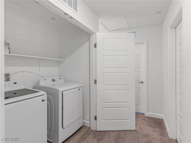 clothes washing area featuring washer and clothes dryer and light colored carpet