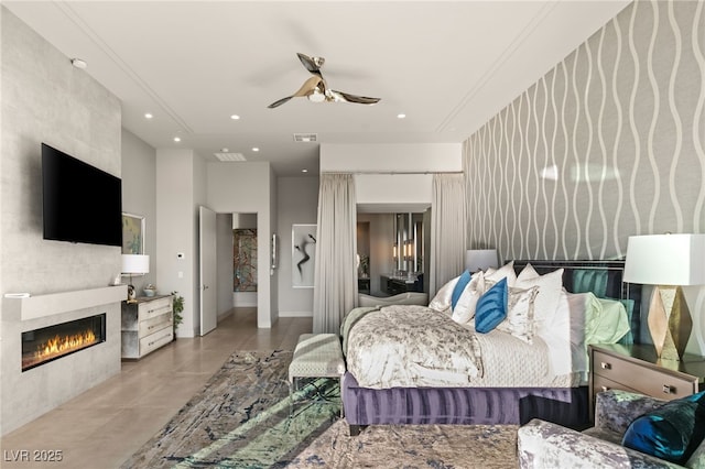 bedroom with a tile fireplace and ceiling fan