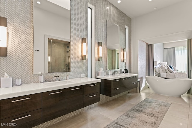 bathroom featuring a towering ceiling, vanity, tile walls, independent shower and bath, and tile patterned flooring