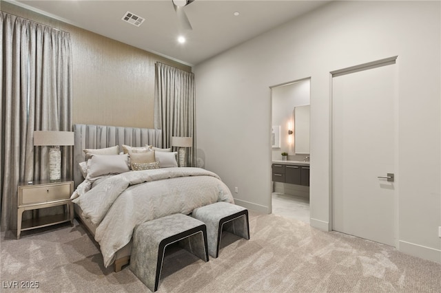 bedroom featuring ensuite bath, ceiling fan, and light carpet