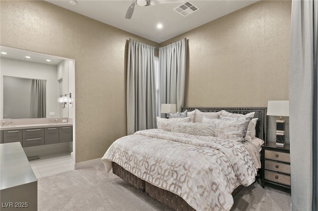 bedroom featuring connected bathroom, light colored carpet, ceiling fan, and sink