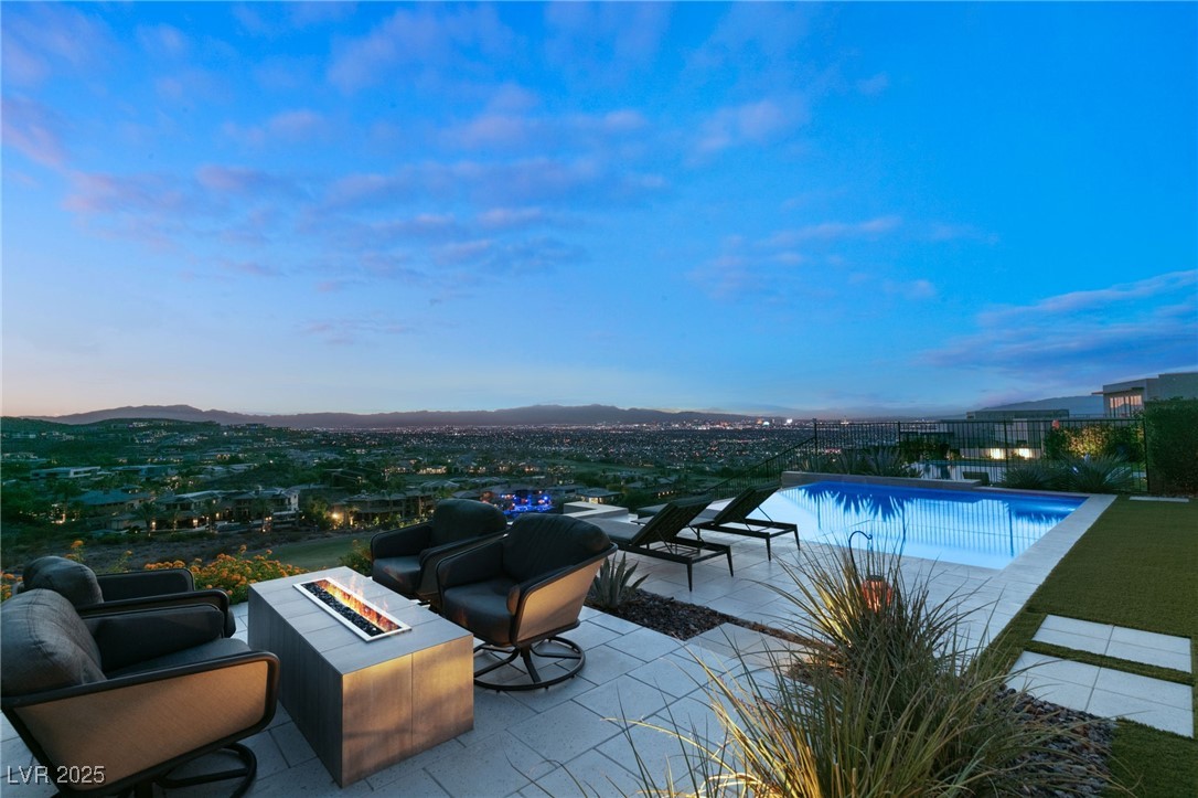 pool at dusk featuring a patio and a fire pit