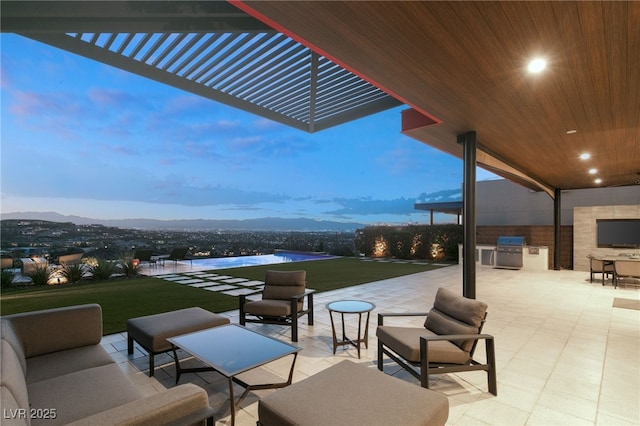 patio terrace at dusk with a yard, a pergola, grilling area, a mountain view, and area for grilling