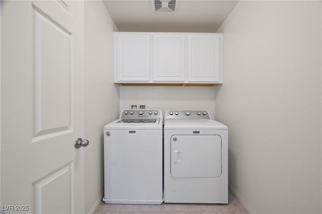 laundry area with washing machine and dryer and cabinets