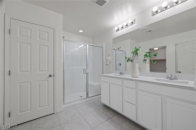 bathroom featuring tile patterned flooring, vanity, and a shower with shower door