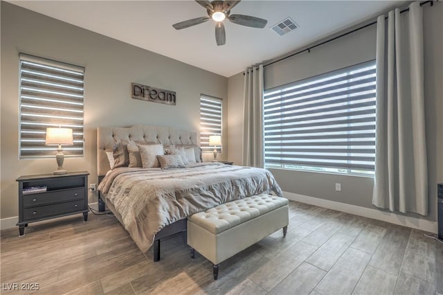 bedroom with ceiling fan and multiple windows