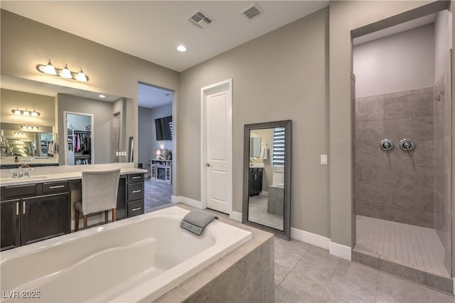 bathroom with plus walk in shower, tile patterned flooring, and vanity