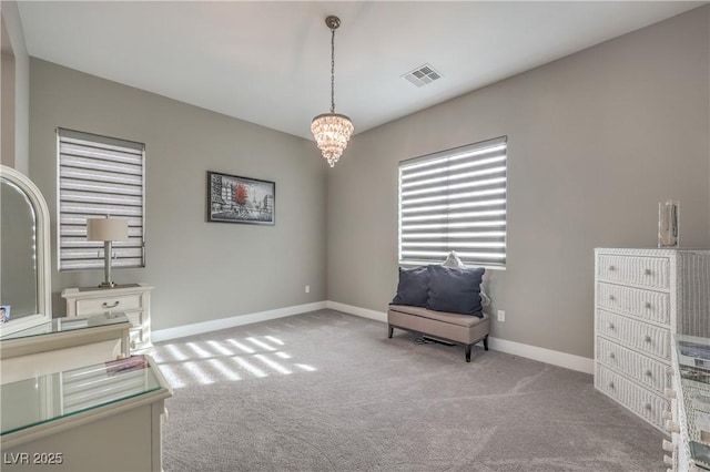 sitting room with light carpet and an inviting chandelier