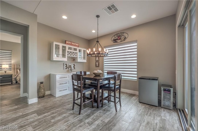 dining area featuring light hardwood / wood-style floors and a chandelier