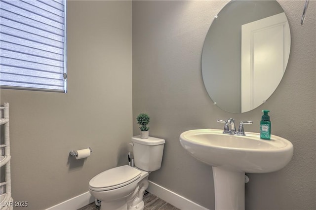 bathroom with hardwood / wood-style flooring, toilet, and sink