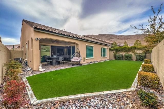 rear view of house featuring a lawn, ceiling fan, and a patio area