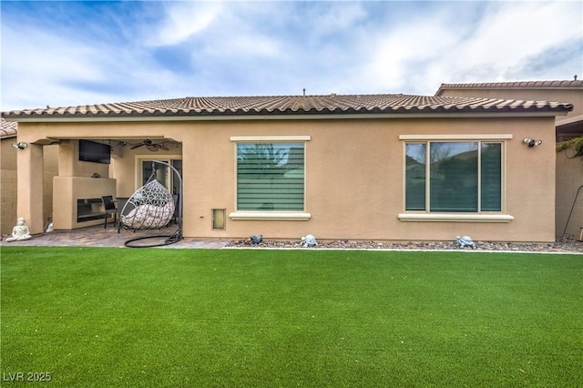 back of property with a patio, ceiling fan, and a lawn