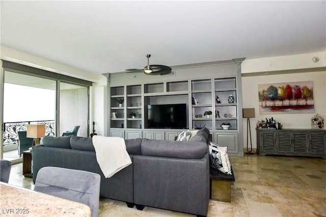 living room with built in shelves and ceiling fan