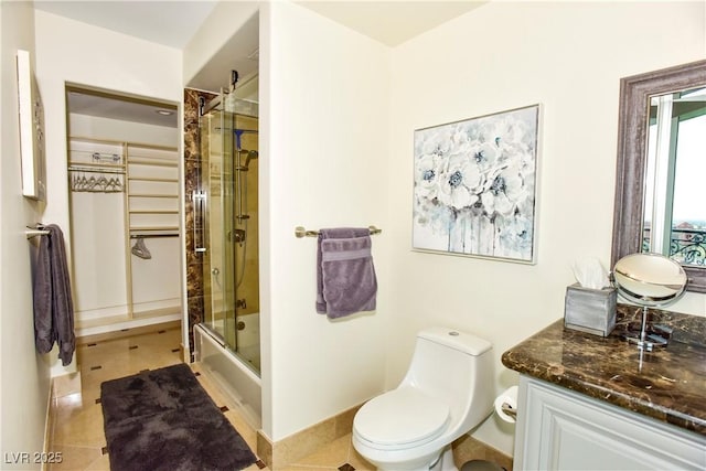 full bathroom featuring toilet, tile patterned flooring, vanity, and combined bath / shower with glass door