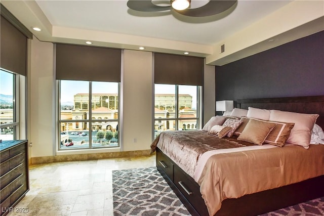 bedroom with ceiling fan and multiple windows